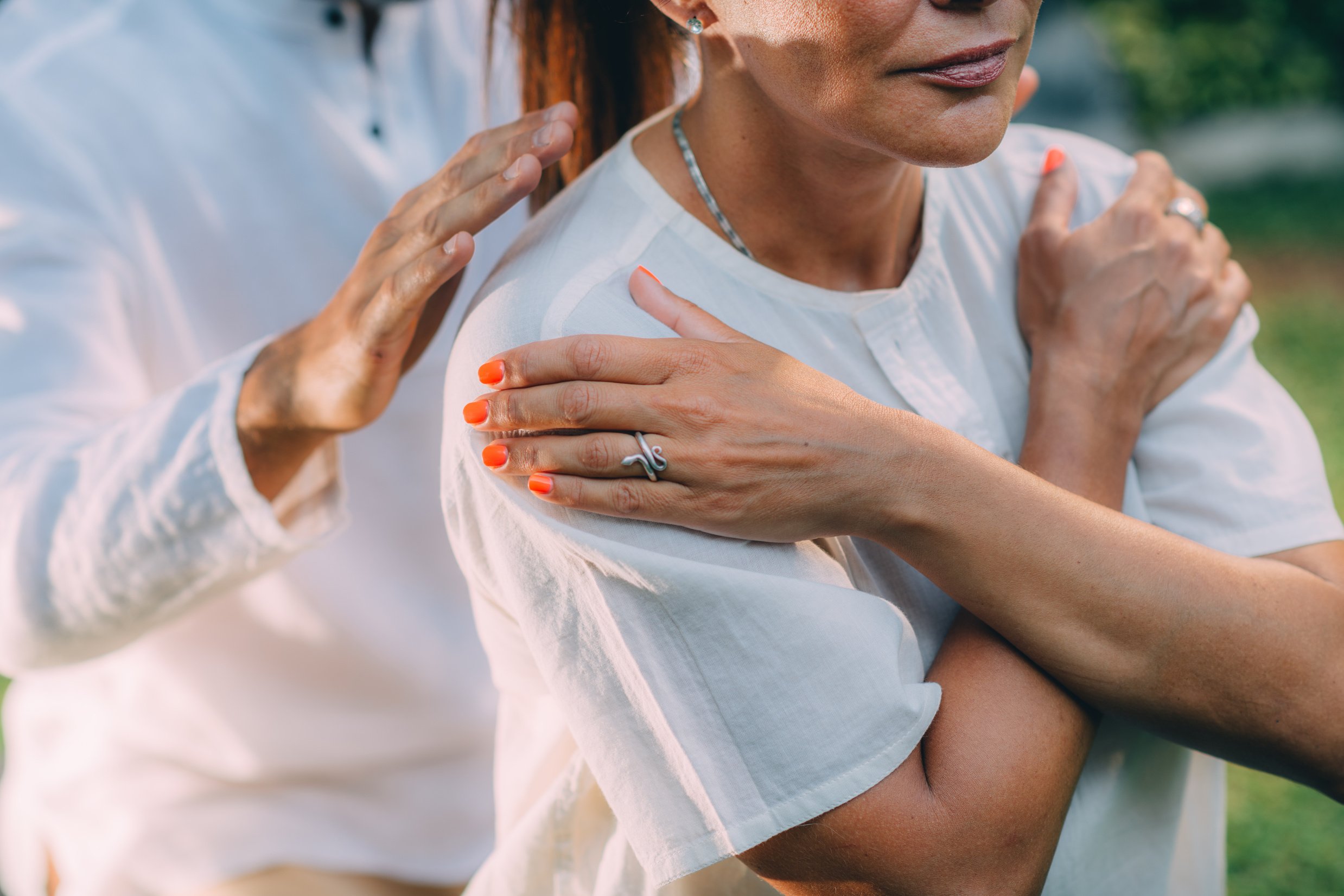 Reiki Lesson. Reiki Instructor With Hands Over Shoulders Of The Course Attendee, Transferring Energy